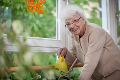 Bewohnerin giesst Blumen