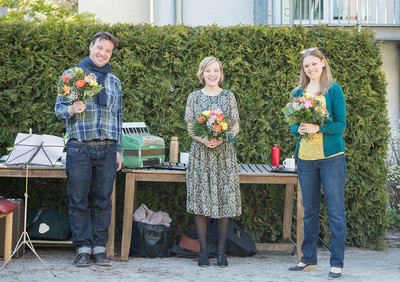 Als Dankeschön erhalten die drei Sänger/innen einen Blumenstrauß